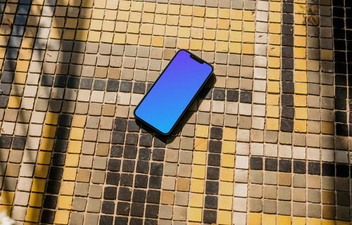 iPhone 13 mockup em um pavimento colorido de um jardim