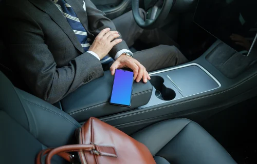 Empresário do sexo masculino na Tesla segurando um telefone