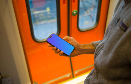 Homem segurando um smartphone no trem