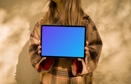 Woman in an autumn coat holding an iPad Air mockup