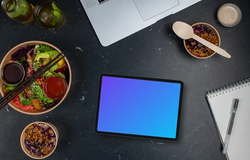 Asian delivery meals next to the tablet mockup
