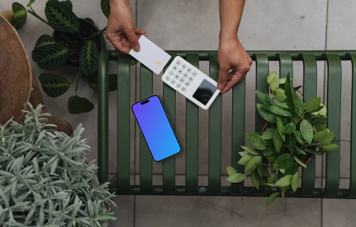 iPhone mockup with credit card terminal amidst plants