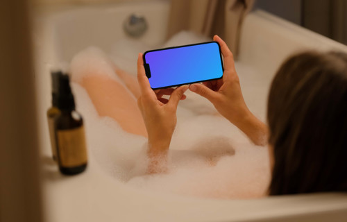 Mulher no banho segurando um iPhone 13 mockup
