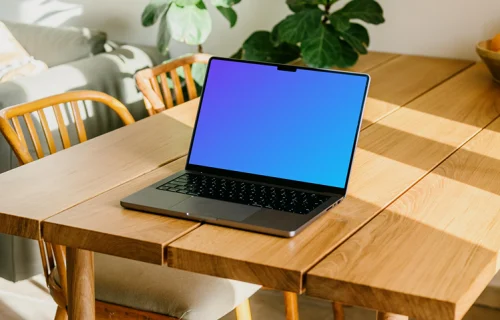 Free MacBook Pro mockup on a table with a plant in the background