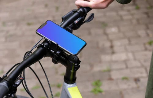 Homem sentado em uma bicicleta com iPhone 11 Pro mockup em montagem de bicicleta
