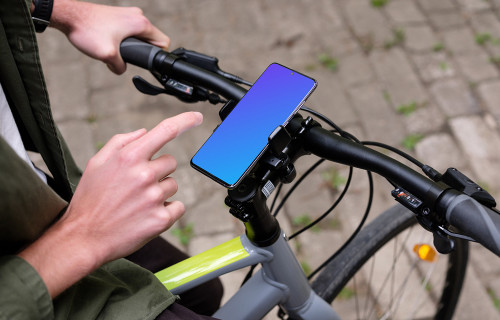 Sentado em uma bicicleta batendo no Samsung S20 mockup em um suporte de bicicleta