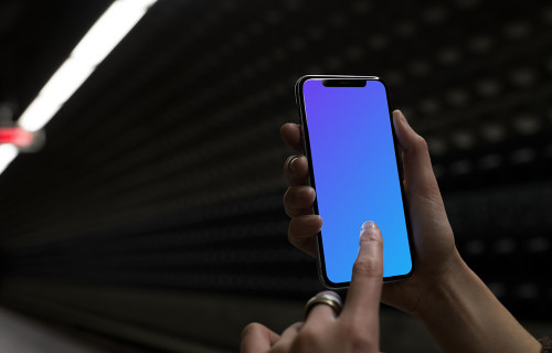 Mulher com iPhone X mockup na estação de metrô