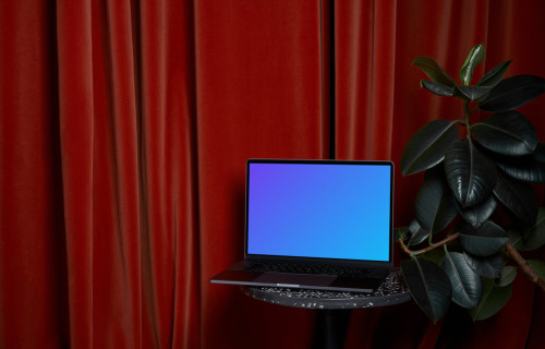 MacBook mockup em um banco ao lado de um vaso de flores