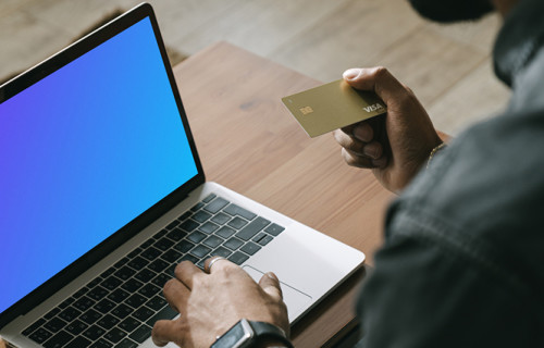 Homem fazendo pagamento on-line com cartão Visa em seu computador MacBook mockup.