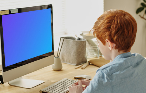 Mockup de uma criança de cabelos vermelhos estudando em um iMac