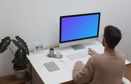 Usuário que utiliza um iMac em seu posto de trabalho